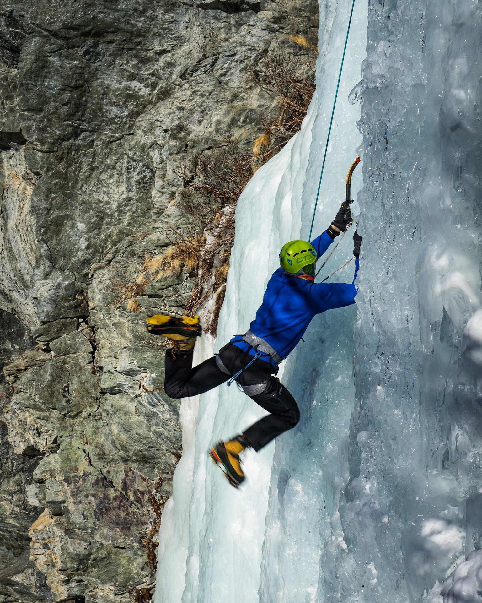 Ice climbing on a frozen waterfall in the Italian Alps